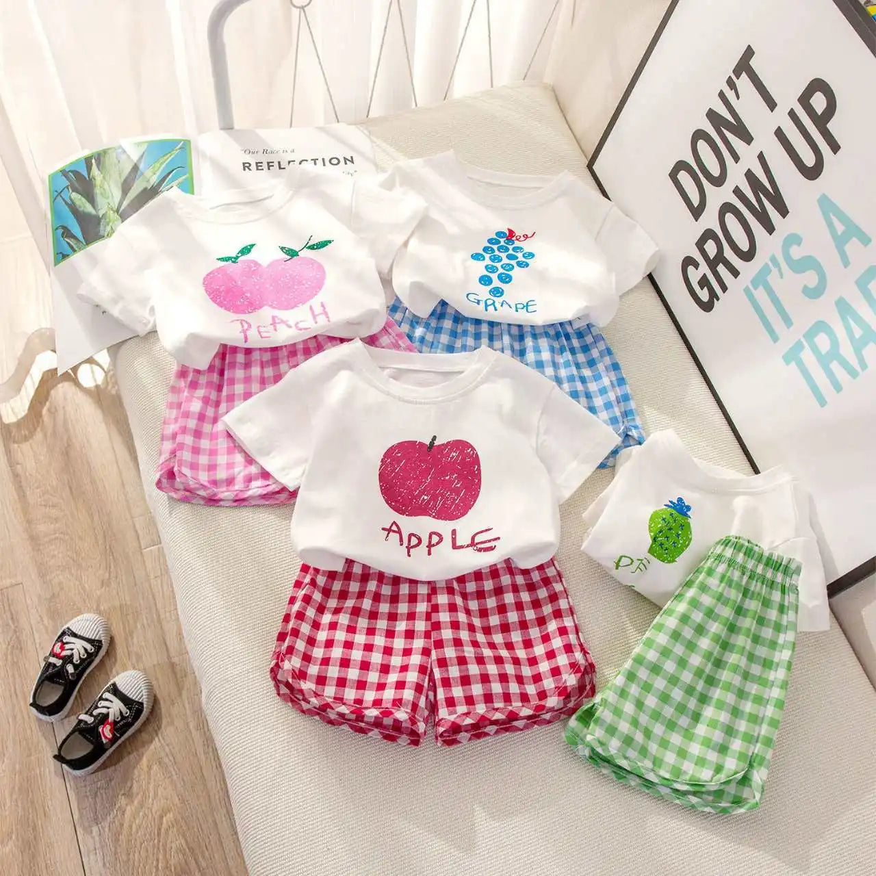 Children's summer outfit by I YAN featuring a short-sleeved round neck top and plaid shorts with fruit and cartoon lemon and grape designs.