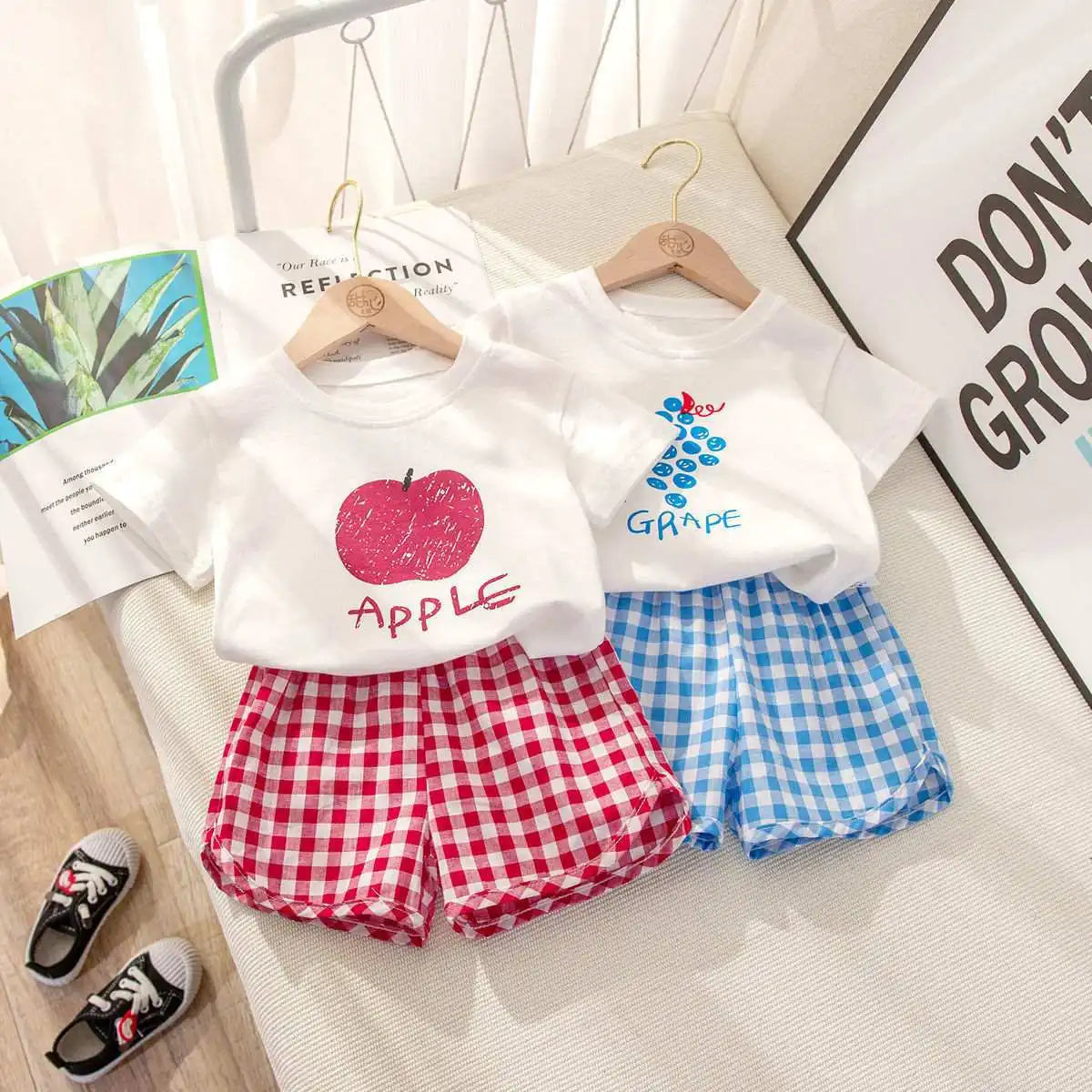 Children's casual summer outfit by I YAN, 2-piece set with short-sleeved round neck top and plaid shorts featuring fruit and cartoon designs.