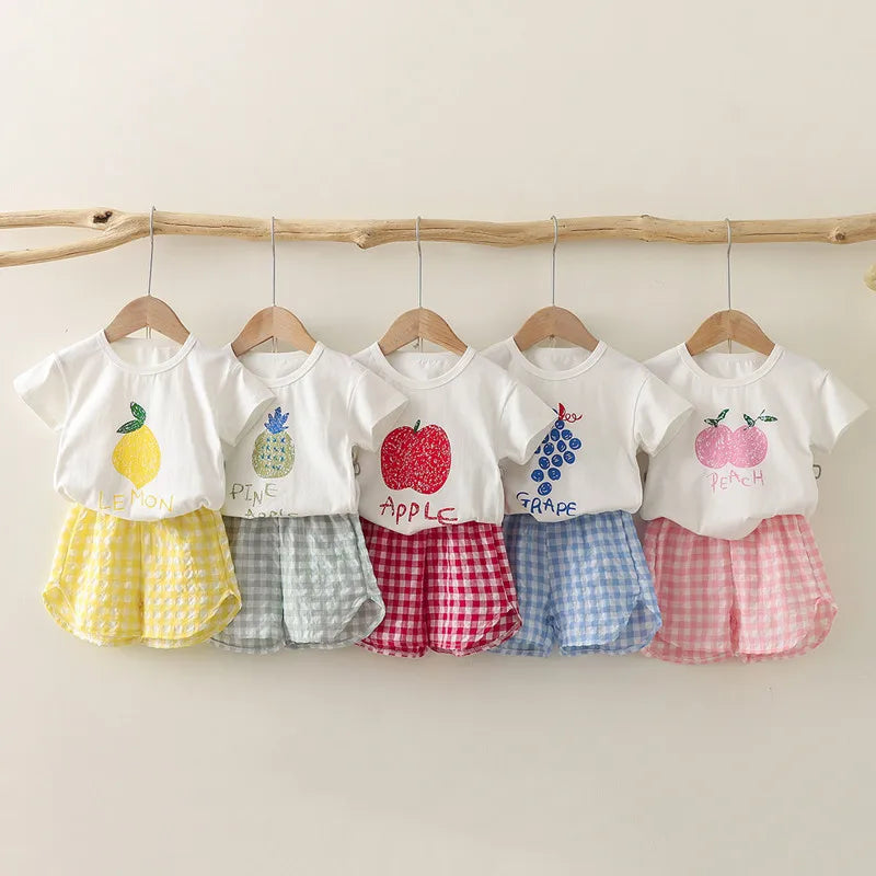 Children's 2-piece summer set by I YAN with short-sleeved round neck top and plaid shorts featuring lemon and grape cartoon prints.